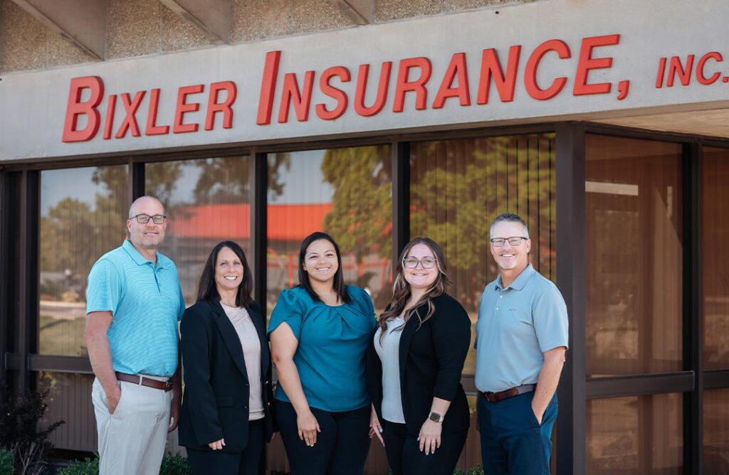 Five people standing in front of the Bixler Insurance, INC building